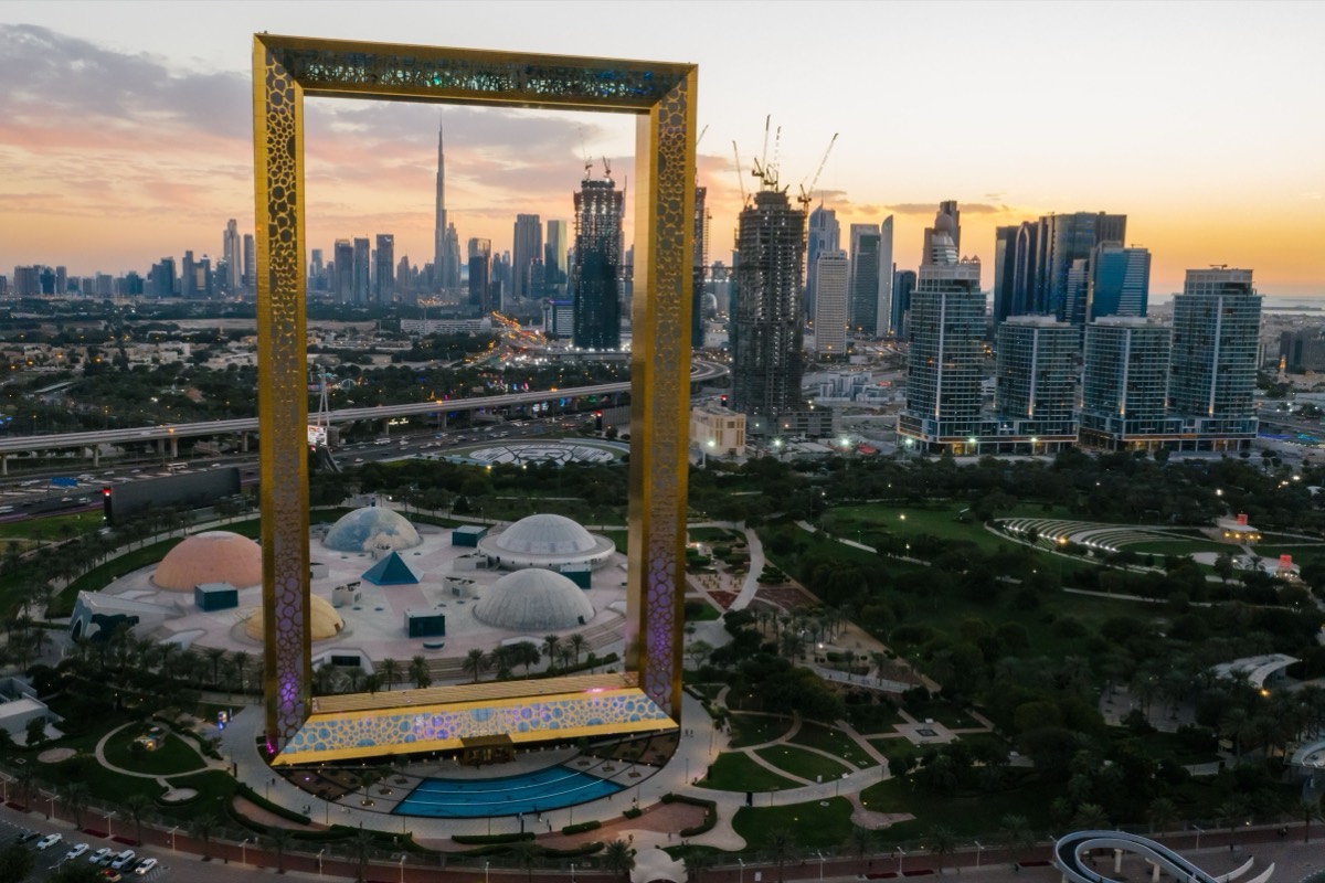 Aerial view at dusk of the Dubai Frame in Zabeel Park, with the Downtown Dubai skyline and the Burj Khalifa behind it, the city a founder from India travels to for the residence visa