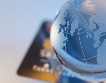 Glass globe resting on a bank card, representing UAE banking accessed from abroad