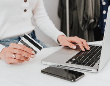 Woman at a laptop holding a bank card while completing an application online